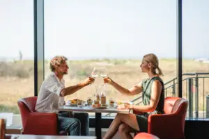 Ein Mann und eine Frau sitzen an einem Tisch mit Weingläsern.