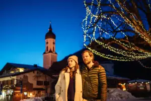 Kerstmis Garmisch Een man en een vrouw staan voor een verlichte boom.