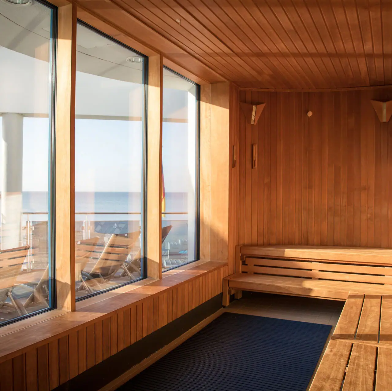 Een kamer met houten muren en ramen.