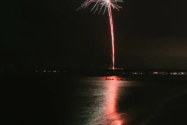 Oudejaarsavond Vuurwerk aan de nachtelijke hemel boven het water