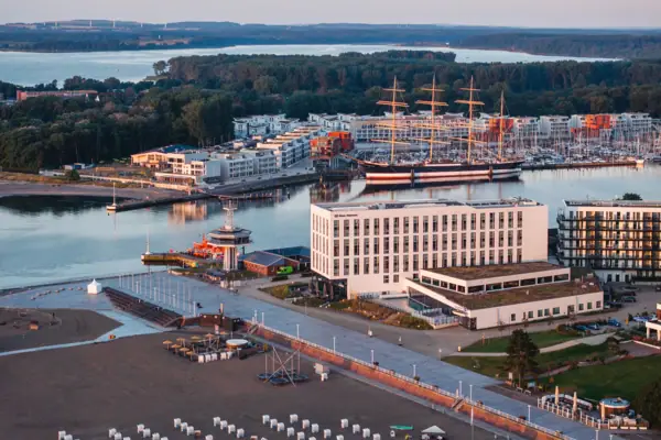 aja Travemünde, drone-opname Luchtfoto vanuit het aja Hotel Travemünde, met het strand voor de deur en de Priwall en de Passat op de achtergrond.