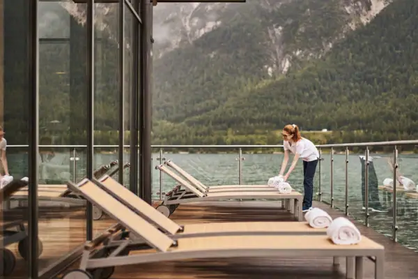 Ligstoelen bij het meer Een vrouw maakt een dek schoon met handdoeken.