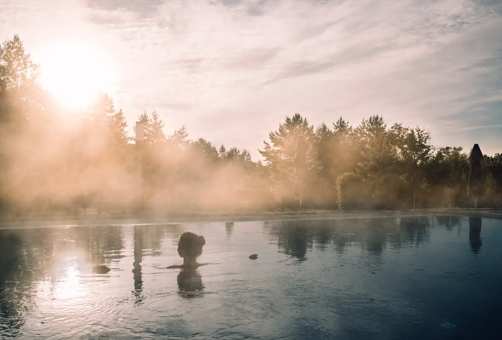 Een persoon in het water, omringd door bomen.