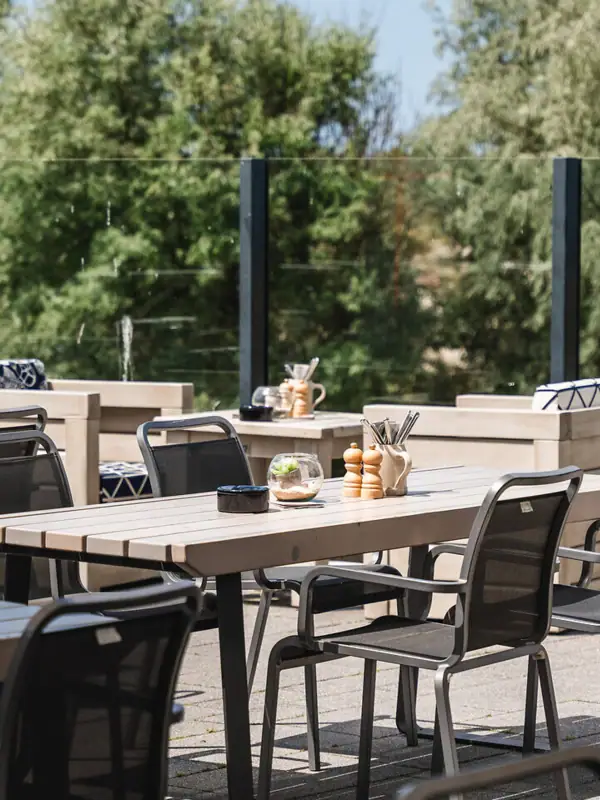 Een tafel en stoelen op een terras.