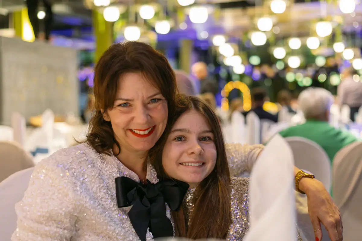 Een vrouw en een meisje lachen voor de camera op het nieuwjaarsfeest bij aja Bad Saarow.