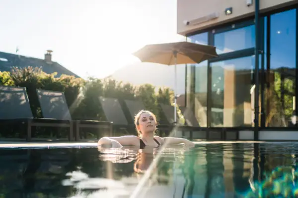 Buitenzwembad Een vrouw zwemt in een buitenzwembad.