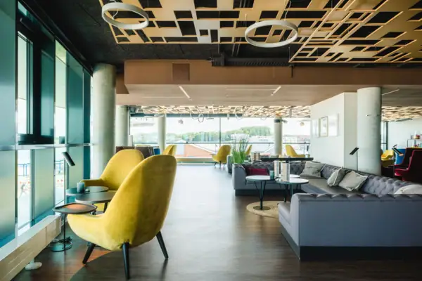 Bar met zitplaatsen Een kamer met een gele stoel en tafels.