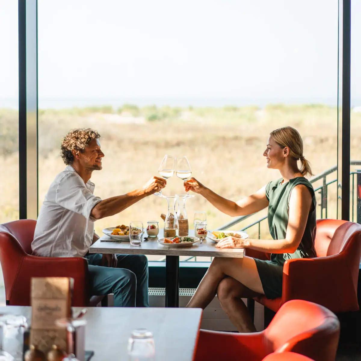 Restaurant bij aja Warnemünde Een man en een vrouw zitten aan een tafel met eten en drinken.