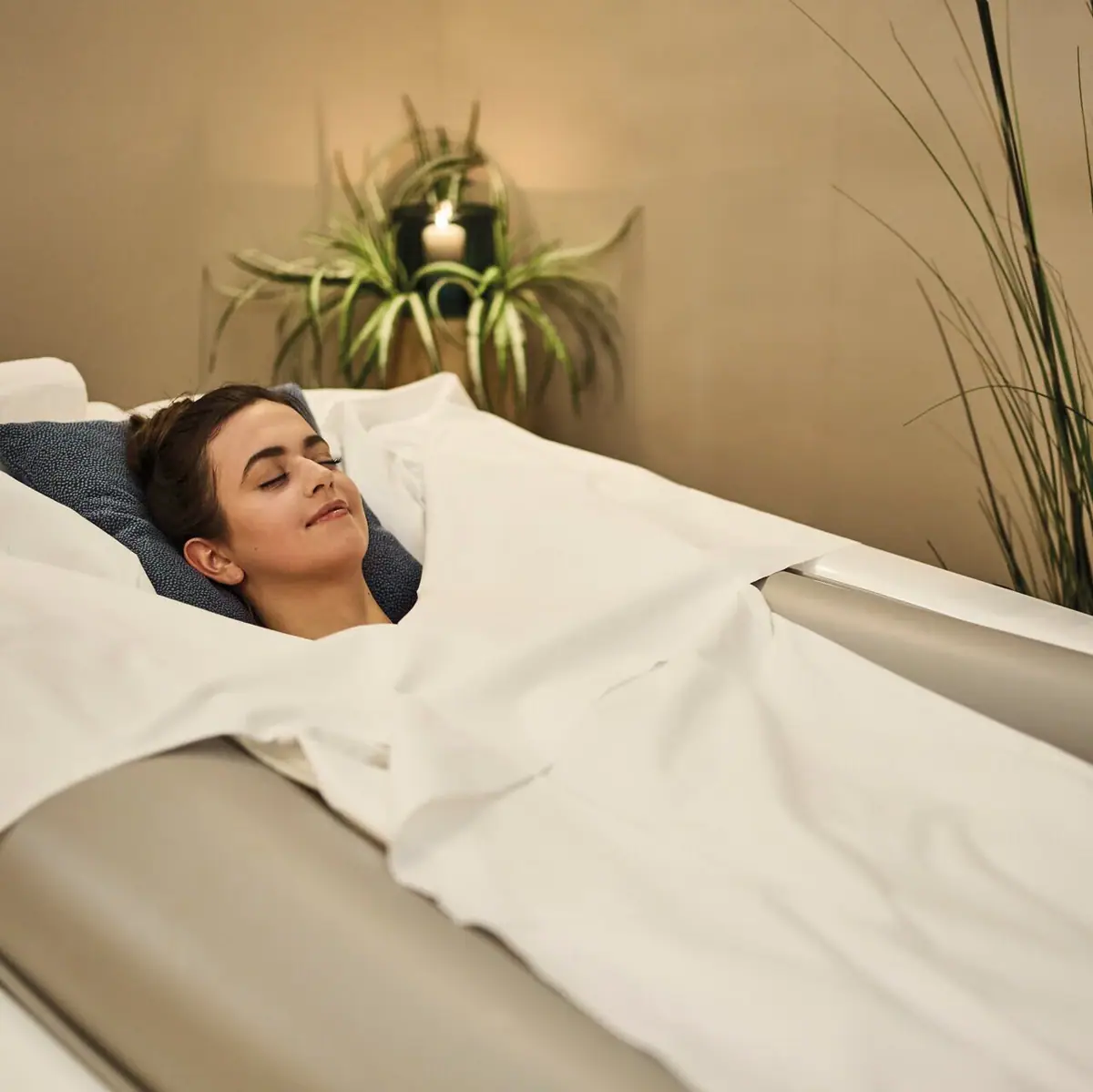 Een vrouw ligt in een bed op een zachte bank