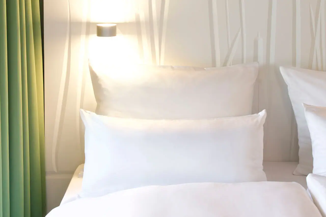 Een kamer met een raam en een bed.