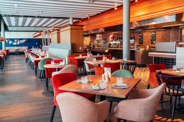 Een restaurant met tafels en stoelen.