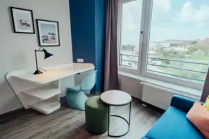 Een kamer met een tafel, een stoel en een raam.