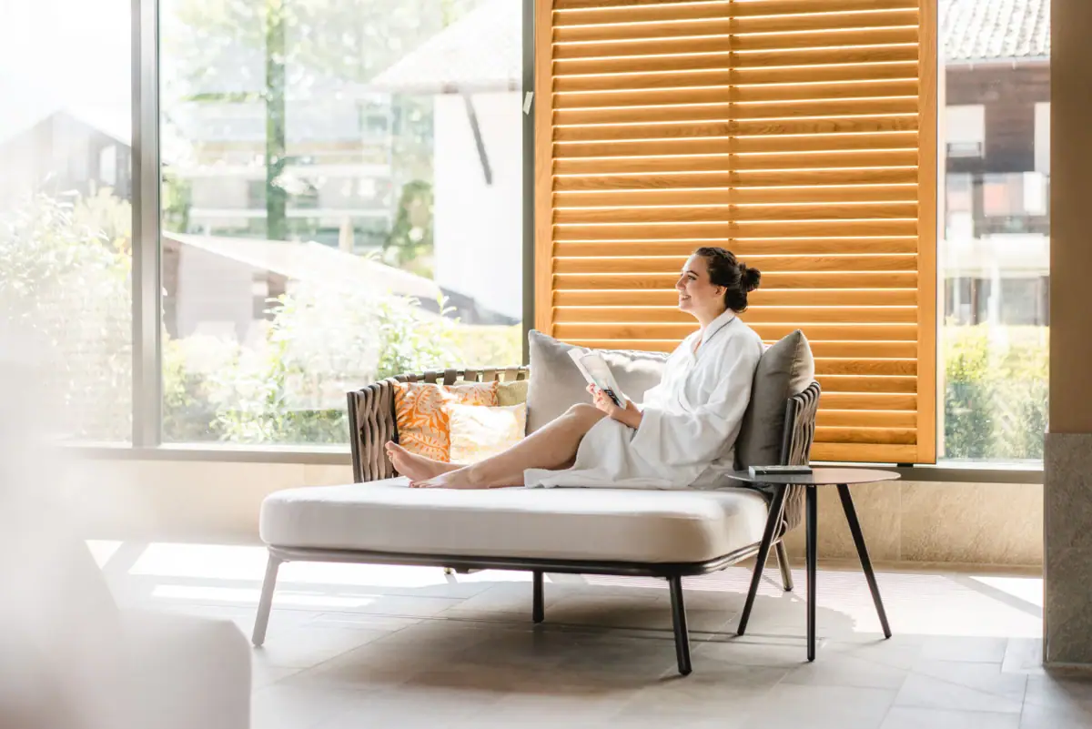 SPA ligstoel Een vrouw in een witte badjas zit op een sofa.