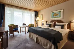 Tweepersoonskamer Slaapkamer met bed en stoelen, voorzien van kussens en beddengoed.