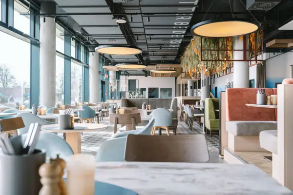 aja Restaurant Ein großes Restaurant mit Tischen und Stühlen.