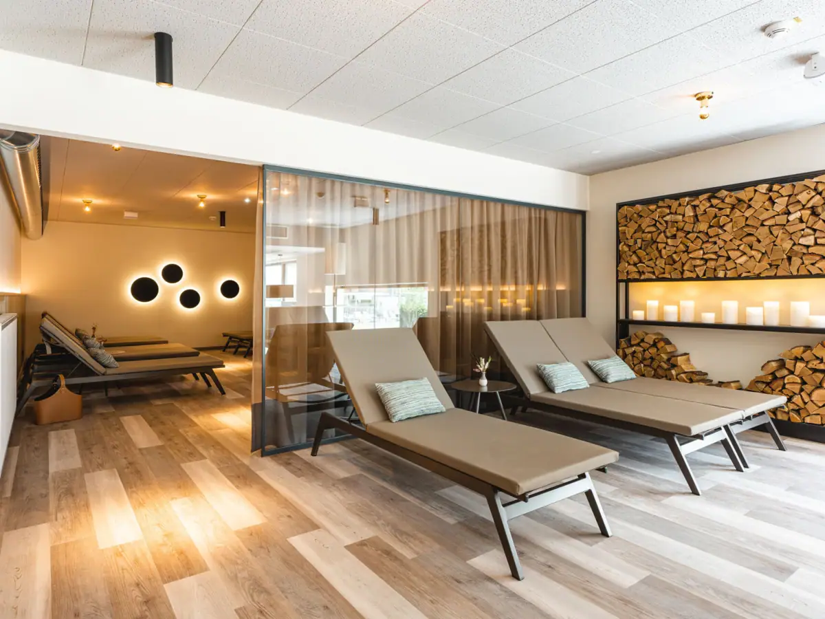 Ontspanningsruimte Een kamer met loungestoelen en houten planken.