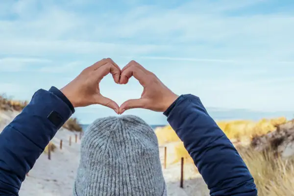 Eine Person formt mit den Händen ein Herz.