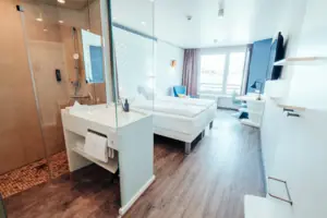 Een kamer met twee bedden en een douche.