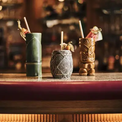 Bar South Beach Een groep tiki-mokken op een toonbank.