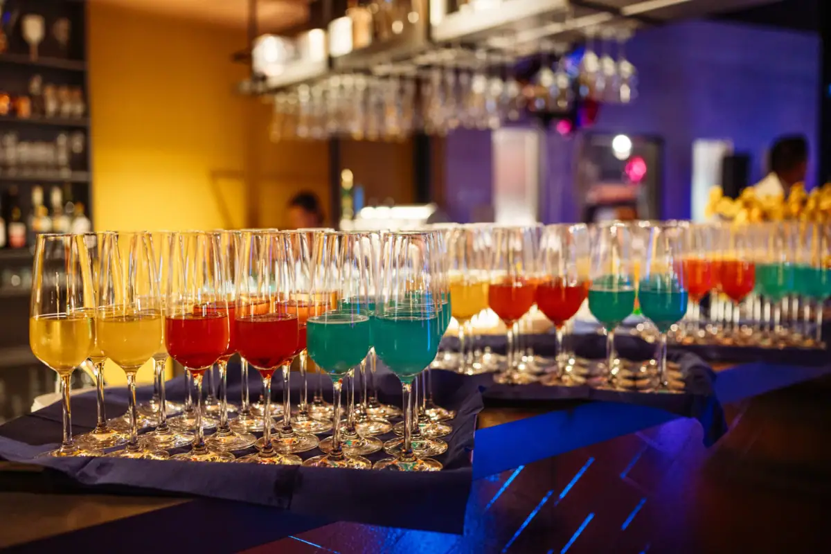 Een groep glazen met verschillende kleuren drankjes.