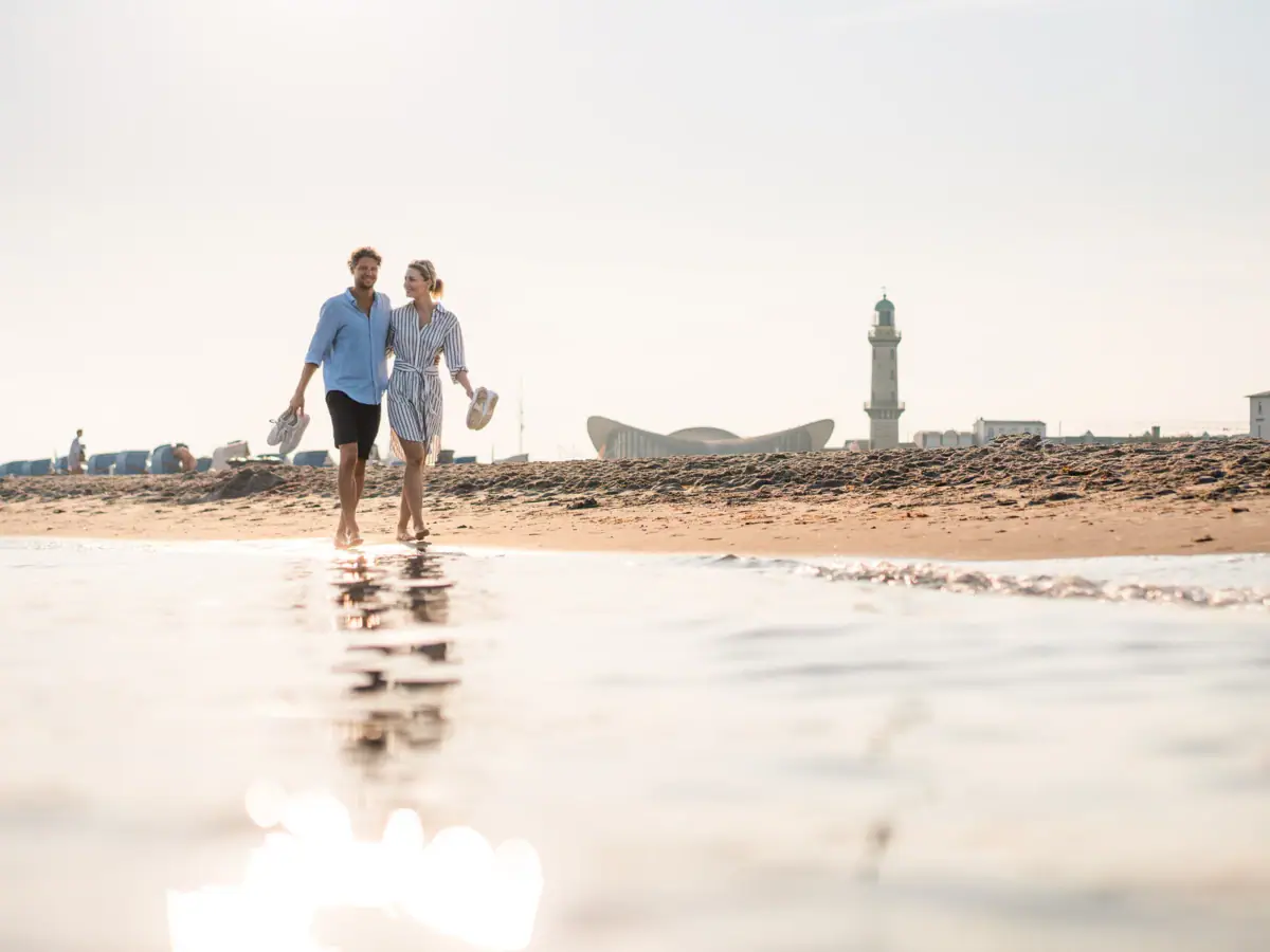Een man en een vrouw lopen langs het strand.