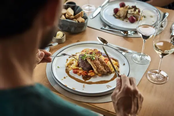 Er zit iemand aan een tafel te eten.