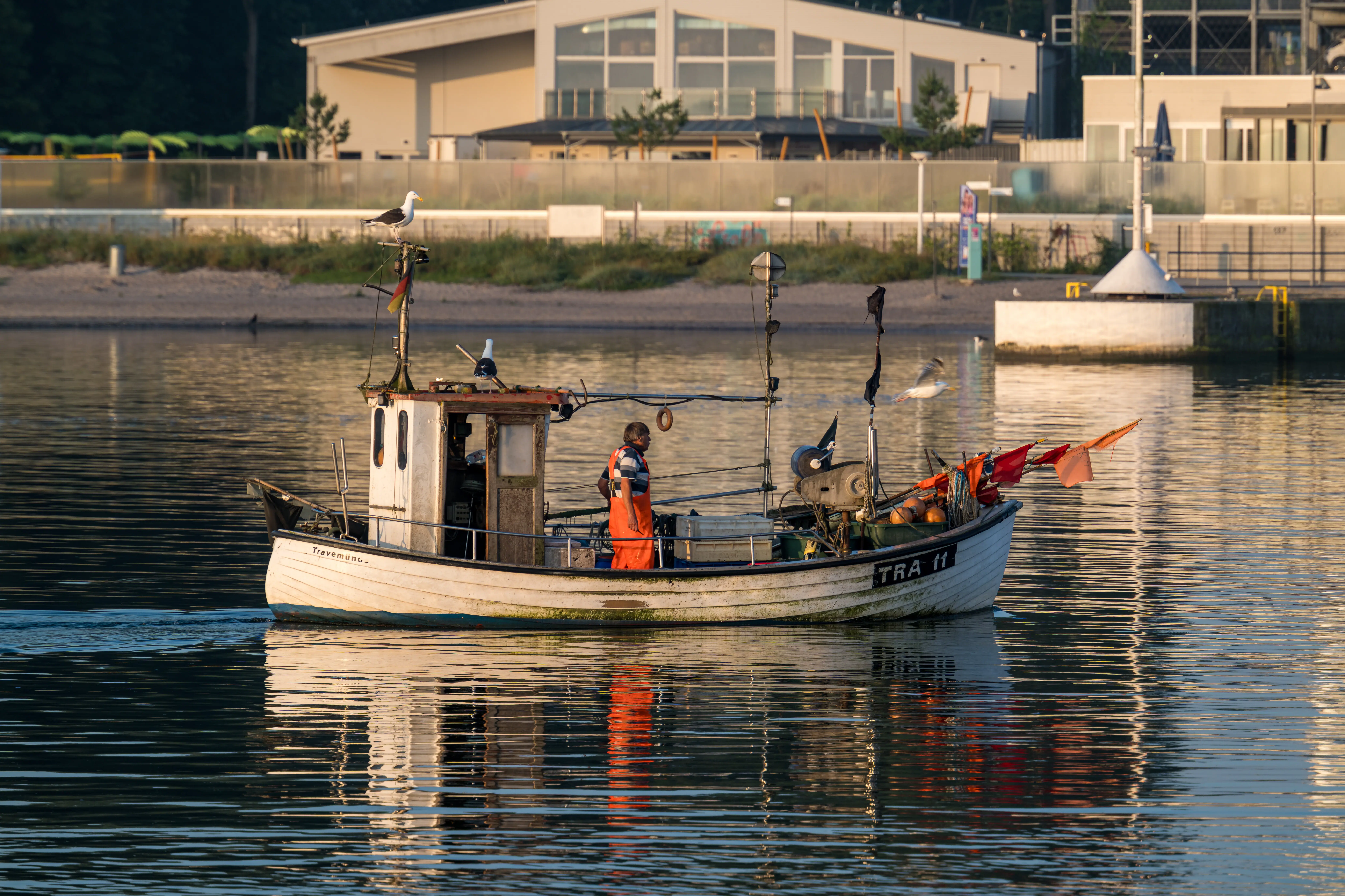 Visser op een kleine vissersboot op de Trave.