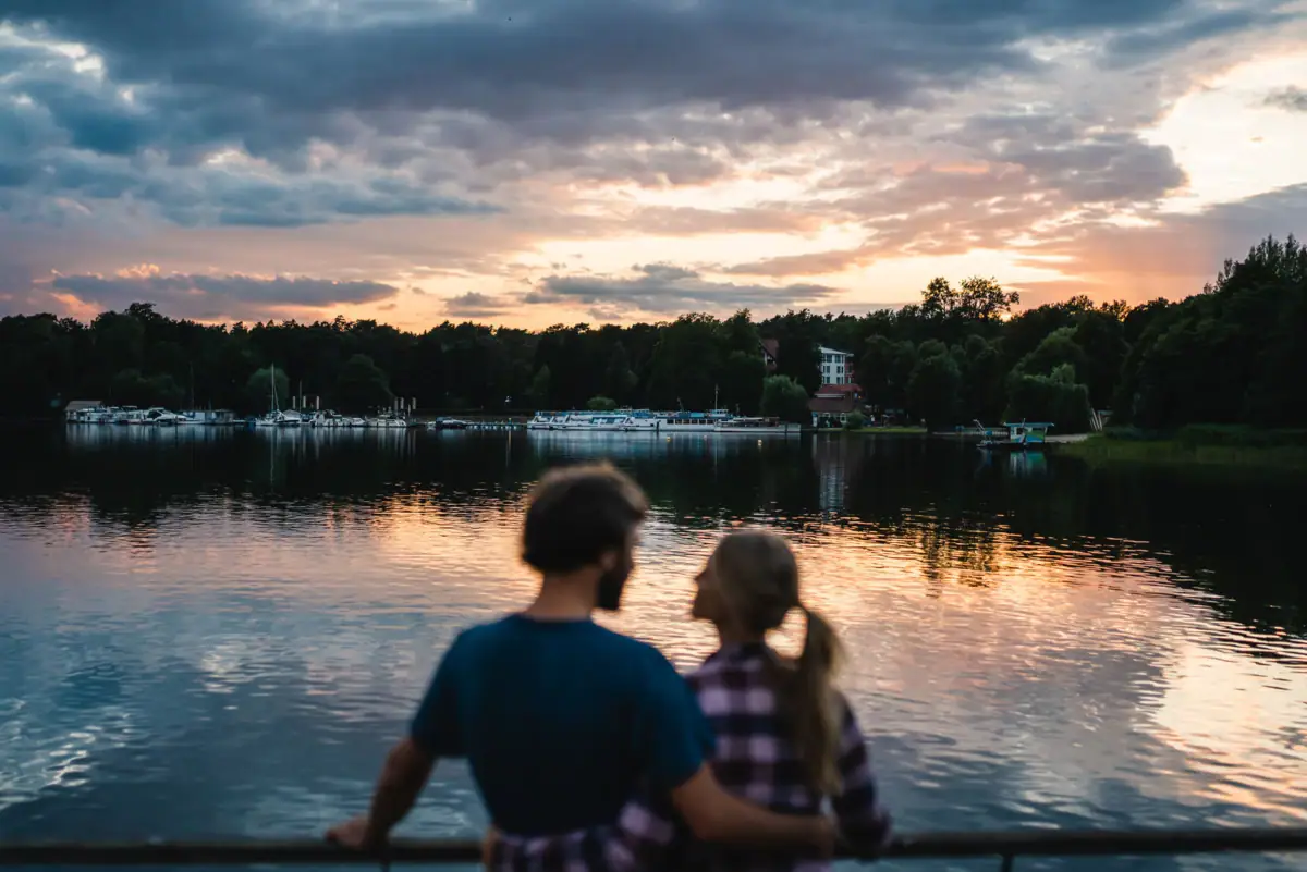 Een man en een vrouw staan bij een watermassa.