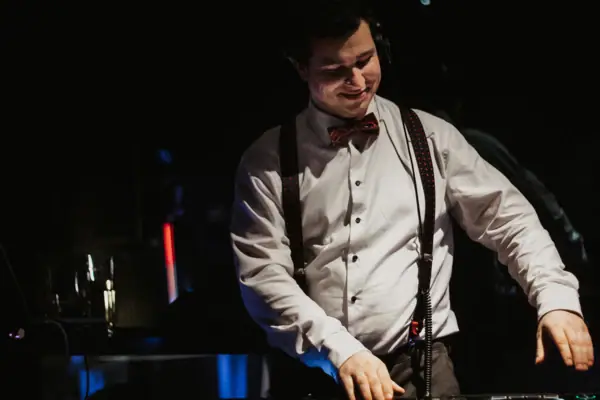 Oudejaarsavond bij aja Warnemünde Een man draagt een vlinderdas en een koptelefoon.