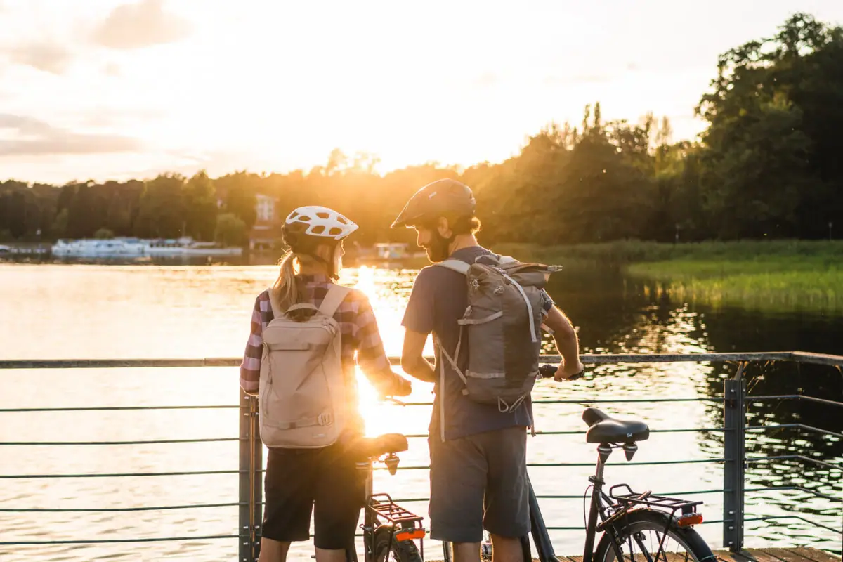 Een man en een vrouw met fietsen op een loopbrug.