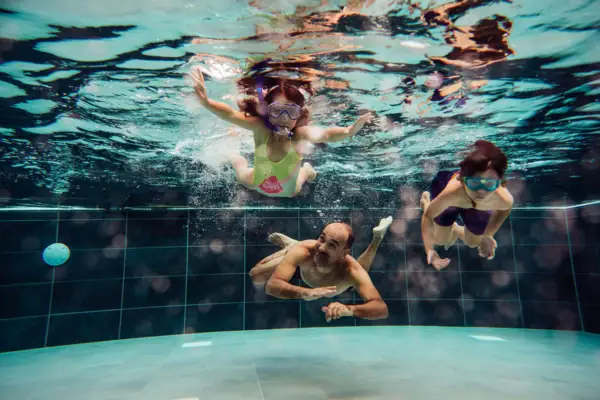 Een groep mensen zwemt onder water.