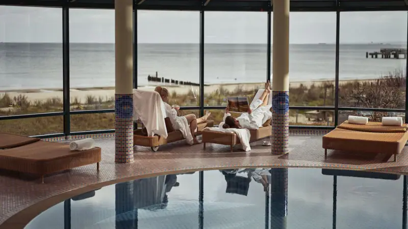 Een stel in witte badjassen bij het zwembad.