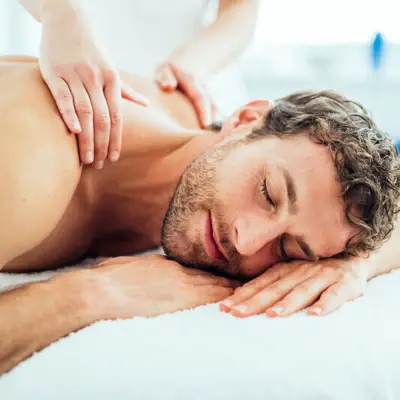 Een man ligt op een wit oppervlak.