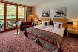 Tweepersoonskamer Een slaapkamer met een bed, een stoel en een tafel.