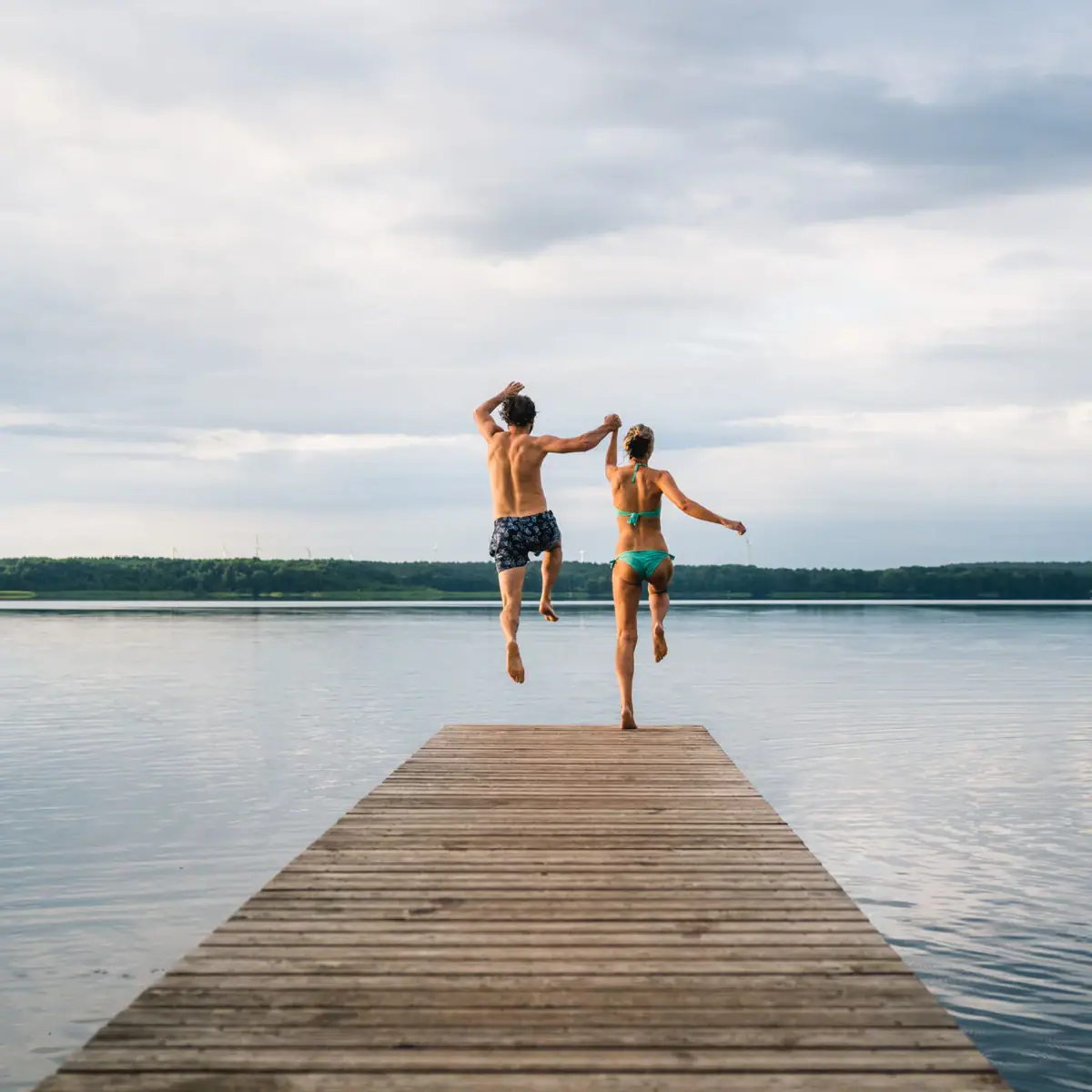 Een man en een vrouw springen in het water.