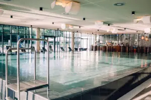 Groot overdekt zwembad met helder water en moderne architectuur.