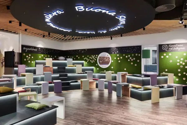 Een ruimte met veel kleurrijke banken en tafels.