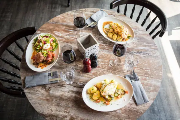Een tafel met borden vol eten en wijnglazen.