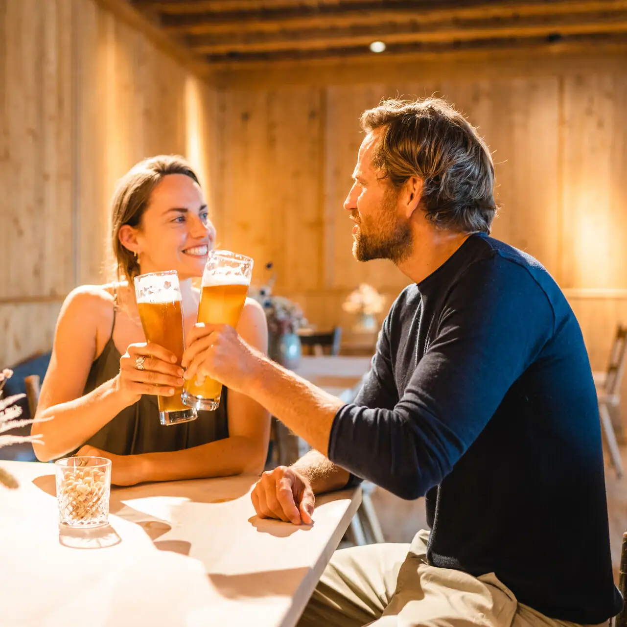 Beierse salon Een man en een vrouw zitten aan een tafel met glazen bier.