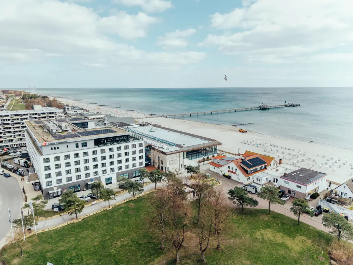 aja Grömitz Een strand met gebouwen en een pier op de voorgrond.