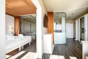 Suite bij de aja Warnemünde Een kamer met een bed en een douche.