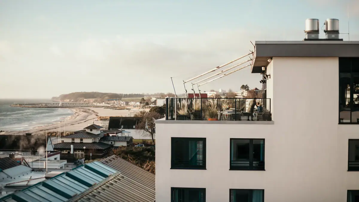 Een gebouw met een balkon dat uitkijkt op het water.