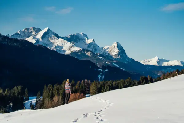 Winter Garmisch Een persoon staat in de sneeuw in een winters berglandschap.