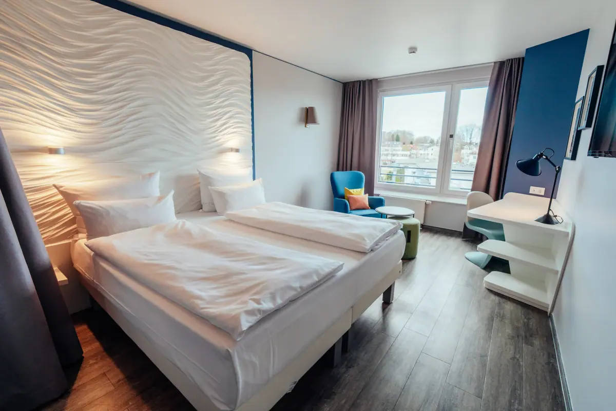 Een kamer met twee bedden en een tafel.