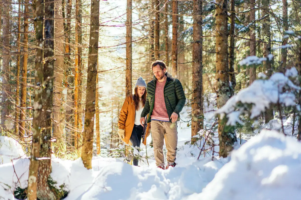 Een man en een vrouw maken een wandeling in de sneeuw.