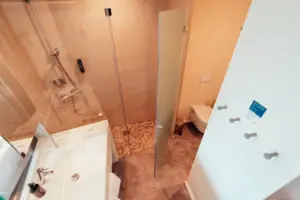 Badkamer met douche met glazen deur en wastafel