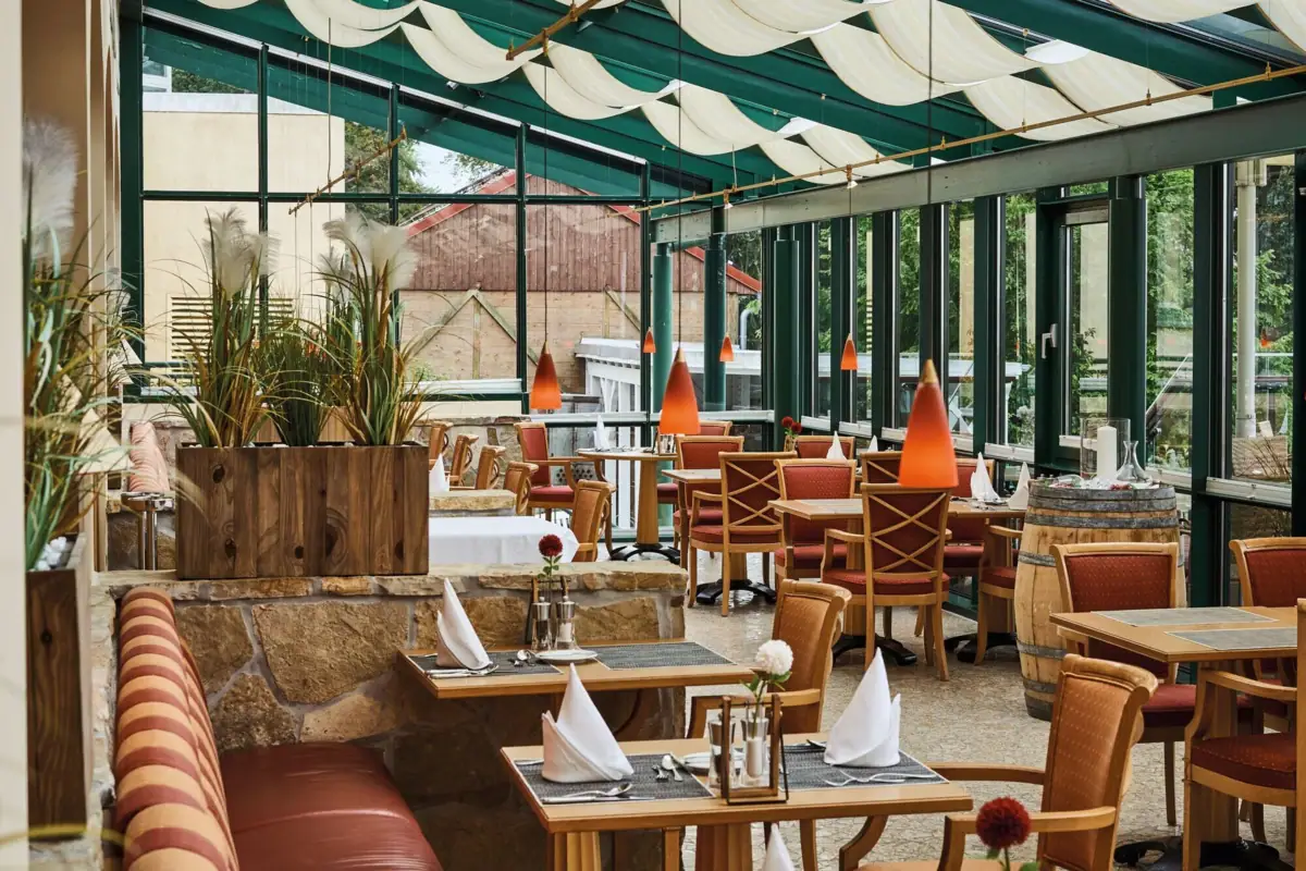 Serre Een restaurant met tafels en stoelen.
