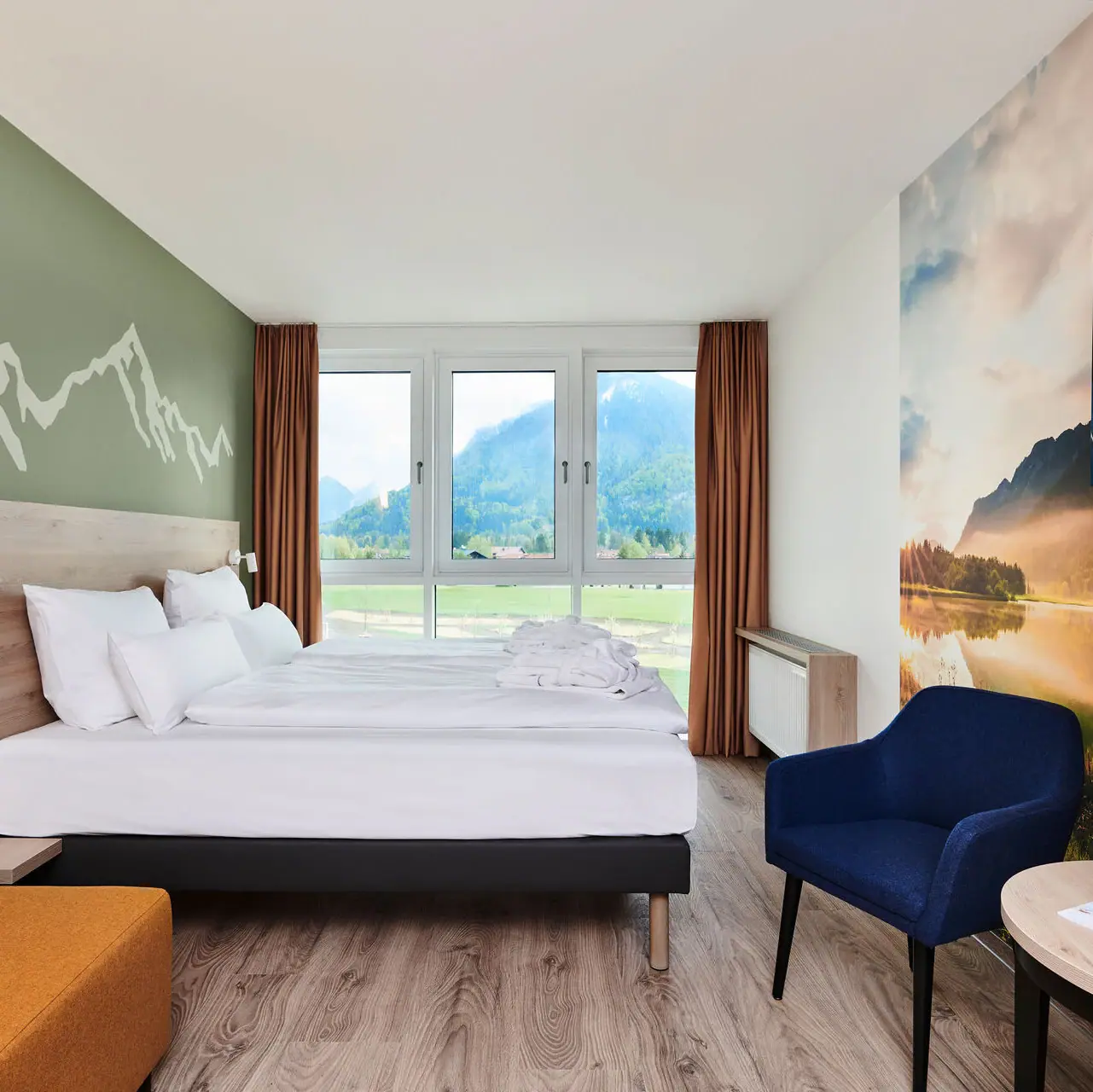 Kamers in het aja Ruhpolding Een kamer met een bed en uitzicht op de bergen vanuit het raam van de aja Ruhpolding.