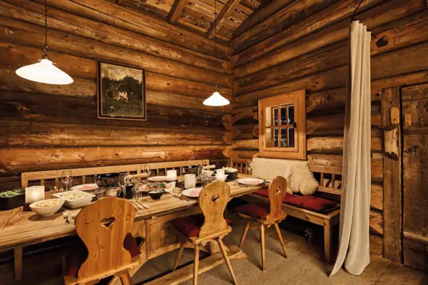 Een gezellige gastenkamer met een tafel en stoelen.