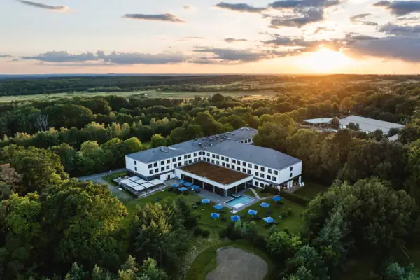 Ein Gebäude mit einem Pool, umgeben von Bäumen.